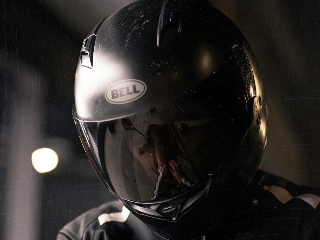 Reflective shot of a motorcyclist wearing a black helmet highlighting safety.
